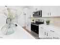 Bright kitchen features white cabinets, stainless steel appliances, granite countertops, and a stylish backsplash at 103 Mable Ct # 25P, Lillington, NC 27546