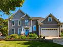 Charming two-story home featuring a well-manicured lawn, blue front door, and attached two-car garage at 1106 Purple Glory Dr, Apex, NC 27502