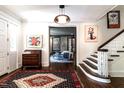 Inviting foyer with dark stained hardwood floors, staircase and view into the living room at 117 Hillcrest Rd, Raleigh, NC 27605