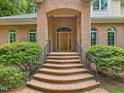 Arched brick entranceway with brick steps and black railings lead to the front door at 1428 Gray Bluff Trl, Chapel Hill, NC 27517