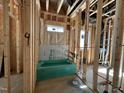 Unfinished bathroom showcasing exposed wooden framing, pipes, and a green bathtub at 1521 Sunrise Ave, Raleigh, NC 27608