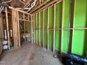 An interior room under construction with exposed wooden framing and green moisture barrier at 1521 Sunrise Ave, Raleigh, NC 27608