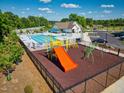 Community playground with slide, climbing equipment, and nearby pool at 158 Ripple Way # 321, Clayton, NC 27520
