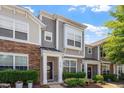 Attractive townhouse with a mix of stone and siding, complemented by manicured shrubs and flowering plants at 1710 Grace Point Rd, Morrisville, NC 27560