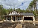 New construction home featuring a covered porch and attached garage under construction at 214 Green Pines Estates Dr, Kenly, NC 27542
