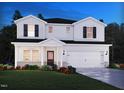 Charming two-story home with white siding, black shutters, landscaped yard, and a two-car garage at 2226 Cherry Creek Rd, Haw River, NC 27258