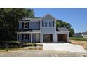 Charming two-story home with attached garage and landscaped yard under a clear blue sky at 2554 Whitetail Rd, Nashville, NC 27856