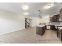 Bright kitchen with a center island, stainless steel appliances, and a clear view to the stairs at 260 Curling Creek Dr # 235P, Clayton, NC 27527