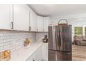 Bright kitchen featuring white cabinets, quartz countertops and a stainless steel refrigerator at 2746 Saint Lukes Church Rd, Goldston, NC 27252