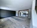 Spacious living room with a dark accent wall leads into a bright, unfinished kitchen, awaiting personalization and finishing touches at 2802 Packing Plant Rd, Smithfield, NC 27577