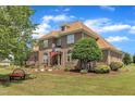 Beautiful two-story brick home featuring mature landscaping and a cozy bench in the front yard at 296 Shoreline Dr, Princeton, NC 27569