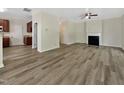 Open-concept living room leading into the kitchen, featuring hardwood flooring and fireplace at 3223 Polite Ln, Raleigh, NC 27610