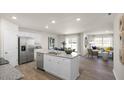 Open-concept kitchen with granite countertops, a kitchen island with seating, and stainless steel appliances at 3608 Sorda Ct, Raleigh, NC 27610