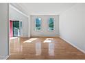 Bright, open-plan living room features hardwood flooring and an entrance with a red door at 3705 Cassaro Ln, Zebulon, NC 27597