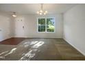 Bright living room featuring a large window, neutral walls and flooring, and modern lighting at 4126 Amber Stone Way, Durham, NC 27704
