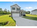Charming two-story home with stone accents, a covered porch, an attached garage, and a well-manicured lawn at 482 Olivia Crossing Ct, Four Oaks, NC 27524