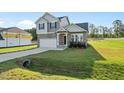 Charming two-story home with stone accents, a covered porch, an attached garage, and a well-manicured lawn at 482 Olivia Crossing Ct, Four Oaks, NC 27524