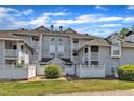 Exterior angle shot of a multi-story apartment building with private balconies and mature shrubs at 4907 Hollenden Dr # 106, Raleigh, NC 27616
