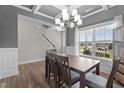 Formal dining room with wainscoting, coffered ceilings, and modern chandelier at 5 Cinnamon Teal Way, Youngsville, NC 27596