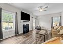 Comfortable living room featuring a fireplace, large TV, and modern ceiling fan at 5 Cinnamon Teal Way, Youngsville, NC 27596