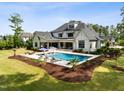 A backyard oasis features a modern pool, lounge area, and covered porch for ultimate relaxation at 5125 Avalaire Oaks Dr, Raleigh, NC 27614