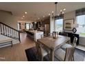 Open-concept dining area next to the kitchen with a stylish table and a view into the living room and staircase at 5906 Dunzo Dr, Raleigh, NC 27617