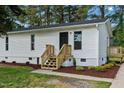 The front entrance boasts a well-maintained vinyl exterior, complemented by a freshly built wooden stairway at 623 Lincoln Dr, Kenly, NC 27542