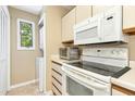 Efficient kitchen includes white appliances, cabinets, and a view to the laundry area at 700 Martin Luther King Jr Blvd # A6, Chapel Hill, NC 27514