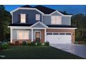 Charming two-story home featuring blue siding, brick accents, a two-car garage, and a well-manicured lawn at 729 Deschutes Dr, Garner, NC 27529