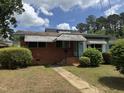 Charming one-story home with brick facade, awnings, and a small front yard at 829 Coleman St, Raleigh, NC 27610