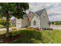 Lovely exterior with a well-maintained lawn, landscaping, and a view of the lake at 1003 Southshore Pkwy, Durham, NC 27703