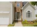 Charming home entrance with stone accents, a dark-colored front door, and well-manicured landscaping at 1003 Southshore Pkwy, Durham, NC 27703