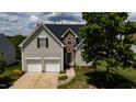 Charming home with a two-car garage, stone accents, a manicured lawn, and beautiful landscaping at 1003 Southshore Pkwy, Durham, NC 27703