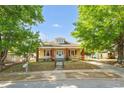 Quaint single-Gathering home featuring a well-manicured lawn and beautiful mature trees shading the front yard at 1007 Grace Ave, Burlington, NC 27217