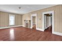 Inviting living room with wood-look floors, neutral walls, a decorative fireplace, and ample natural light at 1007 Grace Ave, Burlington, NC 27217