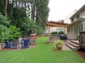 Spacious backyard featuring a built-in grill, patio area, and lush landscaping at 1021 Golden Star Way, Wake Forest, NC 27587