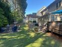 Lush backyard with a pergola over an outdoor kitchen and a separate seating area with a fire pit at 1021 Golden Star Way, Wake Forest, NC 27587
