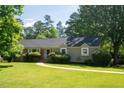 Traditional home featuring a manicured lawn and beautiful green trees at 106 Chariot Dr, Sanford, NC 27330