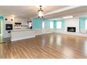 Open-concept space with a white brick fireplace, hardwood floors, and a kitchen area at 110 W Parker St, Smithfield, NC 27577