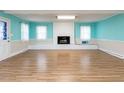 Bright living room with a white brick fireplace, laminate floors, and a large window at 110 W Parker St, Smithfield, NC 27577