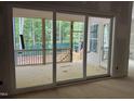View from the living room, sliding glass doors lead to a wooden screened porch and wooded backyard at 118 Sanderway Dr, Chapel Hill, NC 27516