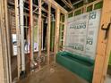 Unfinished bathroom features a green alcove bathtub, stud framing, and exterior sheathing at 1523 Sunrise Ave, Raleigh, NC 27608