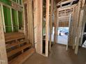 Unfinished entryway with stud framing, stairs, and exterior sheathing at 1523 Sunrise Ave, Raleigh, NC 27608