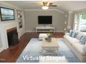 Bright living room boasts a cozy fireplace, built-in shelves, and large windows at 1610 W B St, Butner, NC 27509