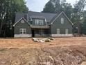 New construction showing a two-story home with green siding and a black roof, surrounded by dirt and construction debris at 194 Landon Ridge, Sanford, NC 27330