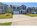Charming two-story home features a spacious driveway, manicured lawn, and blue siding at 244 Potomac River St, Garner, NC 27529