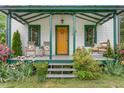 Inviting front porch with rocking chairs, porch swing, and a charming wreath on the front door at 2440 Glencoe St, Burlington, NC 27217