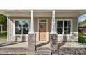 Inviting front entrance with a wooden door and brick-based pillars at 408 W Stallings St, Clayton, NC 27520