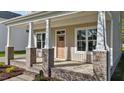Charming front porch with brick accents and a wooden front door, perfect for relaxing outdoors at 408 W Stallings St, Clayton, NC 27520