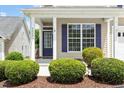 Inviting front porch with blue front door, white columns, and well-maintained landscaping at 4509 Joe Cotton Dr, Knightdale, NC 27545